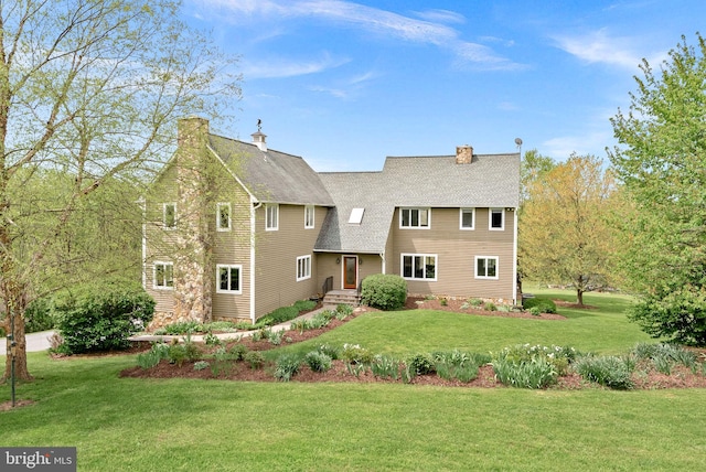 view of front of property featuring a front yard, roof with shingles, and a chimney