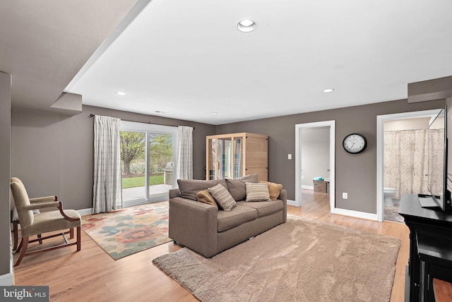living area with baseboards, recessed lighting, and light wood-style floors
