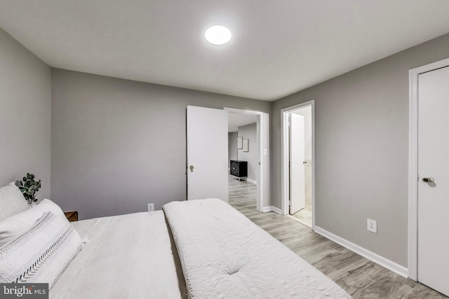 bedroom with baseboards and light wood finished floors