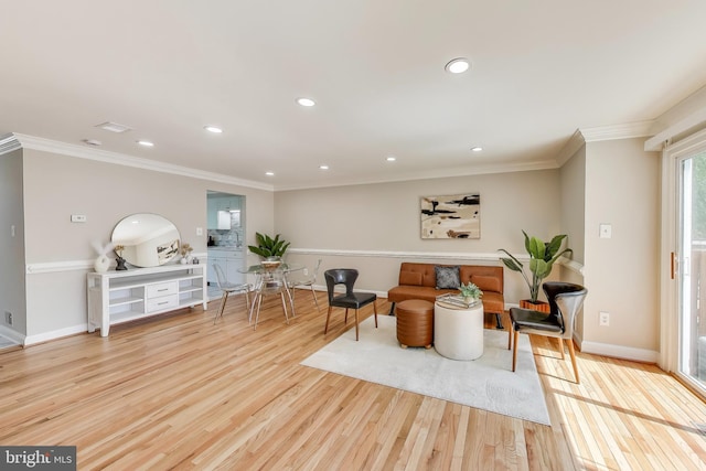 sitting room with baseboards, ornamental molding, and wood finished floors
