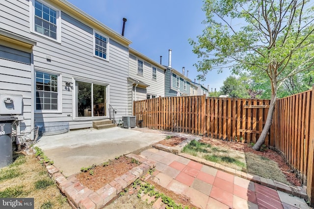 rear view of house featuring central air condition unit, a patio, and a fenced backyard