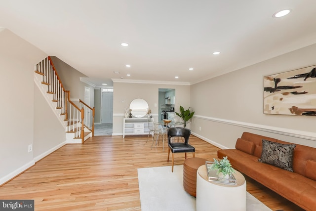 living area featuring light wood-style floors, ornamental molding, recessed lighting, and stairway