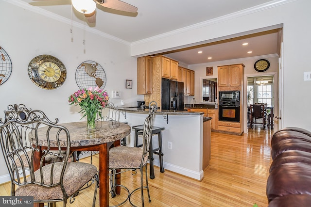 107 Washington Square Ct, Occoquan, VA 22125 - kitchen with a ceiling fan, dark countertops, black appliances, a peninsula, and light wood-style floors