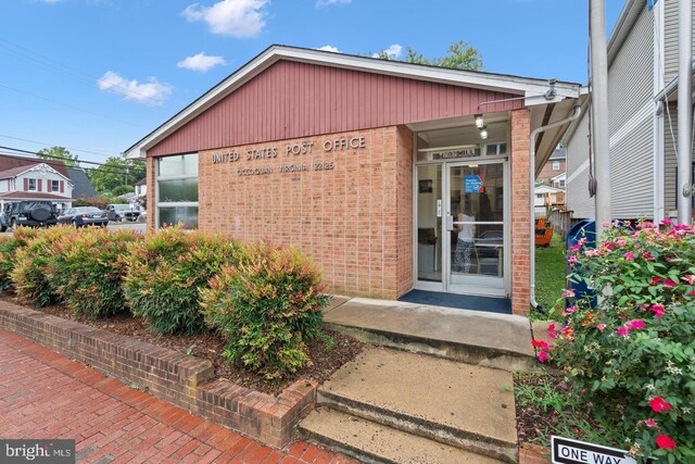 107 Washington Square Ct, Occoquan, VA 22125 - doorway to property featuring covered porch and brick siding