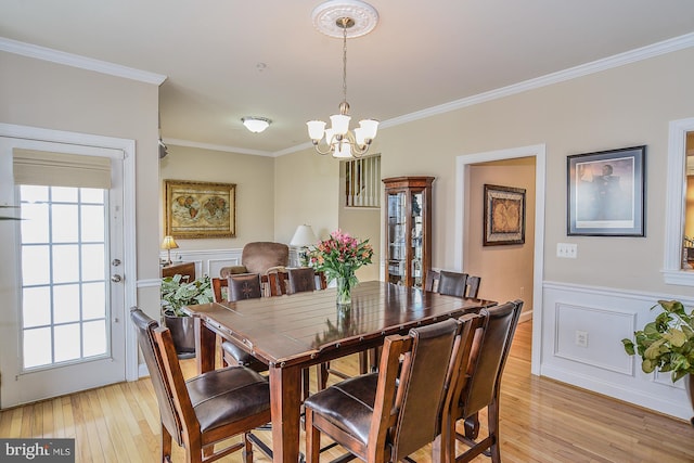 107 Washington Square Ct, Occoquan, VA 22125 - dining area featuring ornamental molding, light wood-style flooring, wainscoting, and a notable chandelier