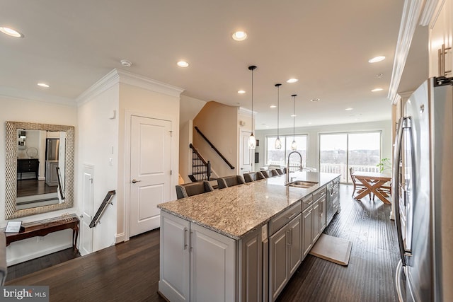 kitchen with a sink, freestanding refrigerator, recessed lighting, dark wood finished floors, and an island with sink