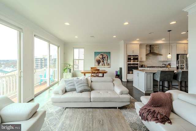 living room featuring recessed lighting, ornamental molding, and wood finished floors