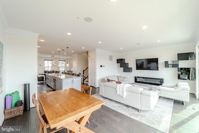 living area with crown molding, recessed lighting, stairway, and wood finished floors