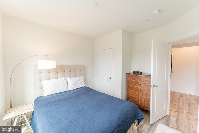 bedroom featuring baseboards and light wood finished floors