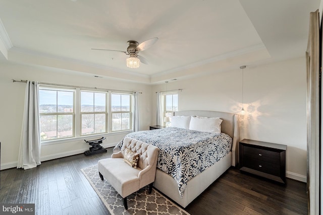 bedroom featuring crown molding, dark wood-style flooring, and a raised ceiling