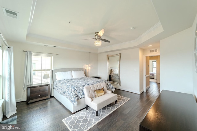bedroom with visible vents, multiple windows, and a tray ceiling