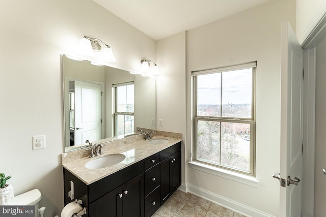 bathroom featuring plenty of natural light, toilet, and a sink