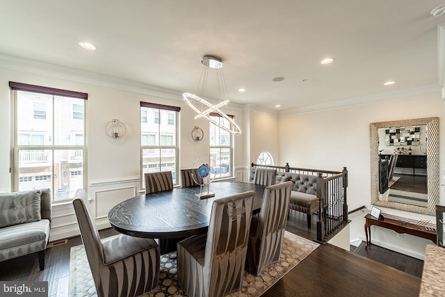 dining space featuring a healthy amount of sunlight, wainscoting, wood finished floors, and a notable chandelier