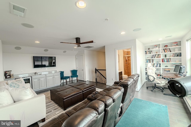 living room with visible vents, wood finished floors, wine cooler, and recessed lighting