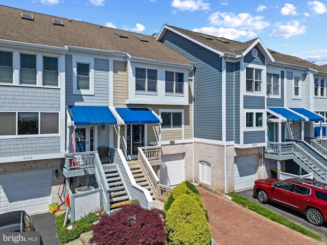 8074 Windward Key Dr, Chesapeake Beach, MD 20732 - view of property with a garage, brick siding, stairway, and driveway