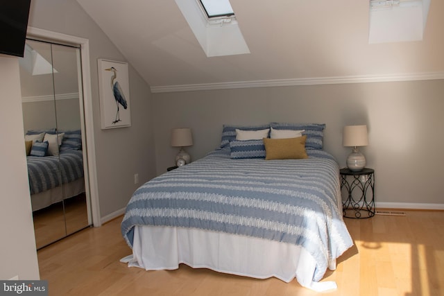 8074 Windward Key Dr, Chesapeake Beach, MD 20732 - bedroom with a skylight, wood finished floors, a closet, baseboards, and lofted ceiling