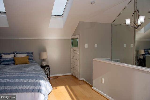 8074 Windward Key Dr, Chesapeake Beach, MD 20732 - bedroom featuring light wood-style floors, a skylight, vaulted ceiling, baseboards, and ornamental molding