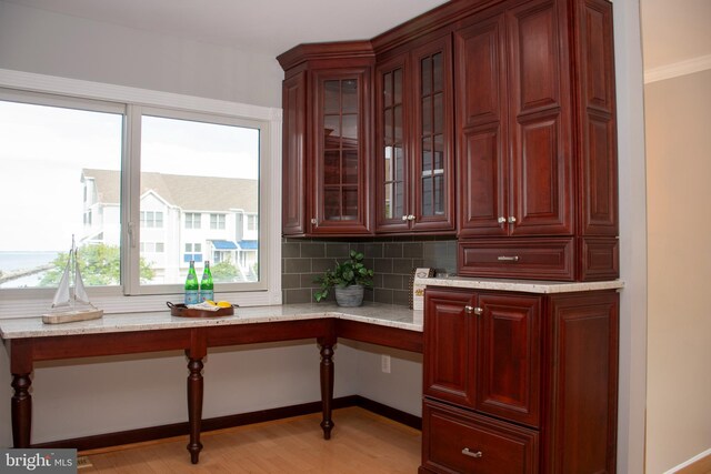 8074 Windward Key Dr, Chesapeake Beach, MD 20732 - bar area featuring light wood finished floors, backsplash, built in desk, and baseboards