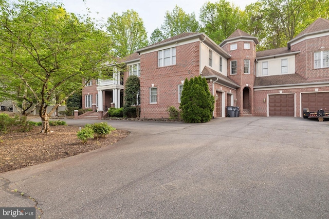 view of front facade featuring brick siding, driveway, and an attached garage