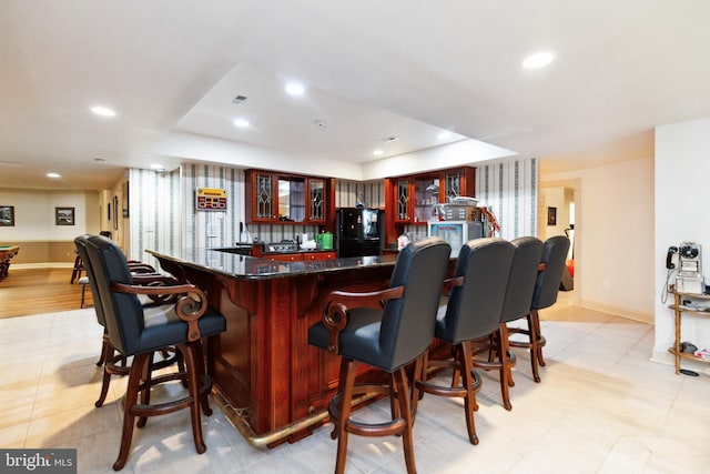 bar featuring bar area, baseboards, recessed lighting, and freestanding refrigerator