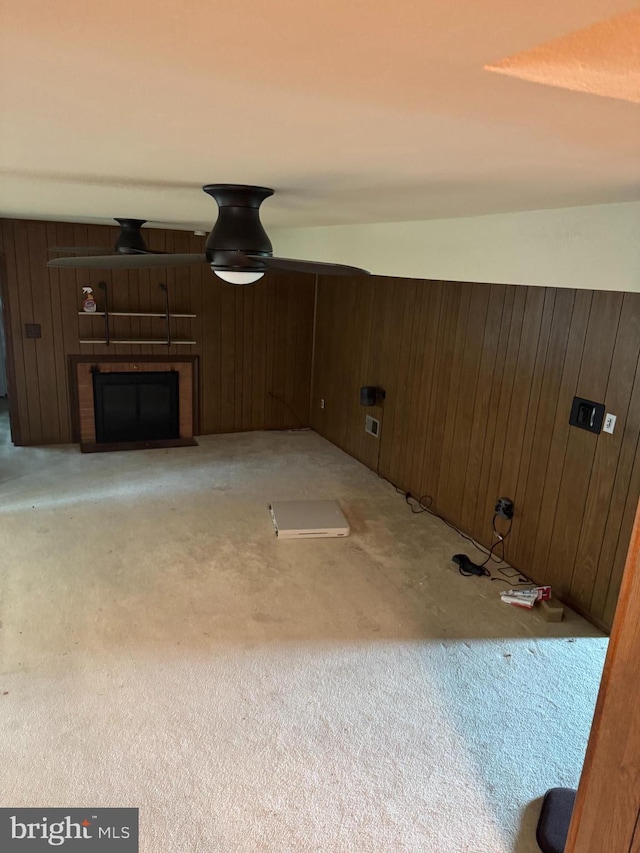 unfurnished living room featuring wood walls, a fireplace, and light colored carpet