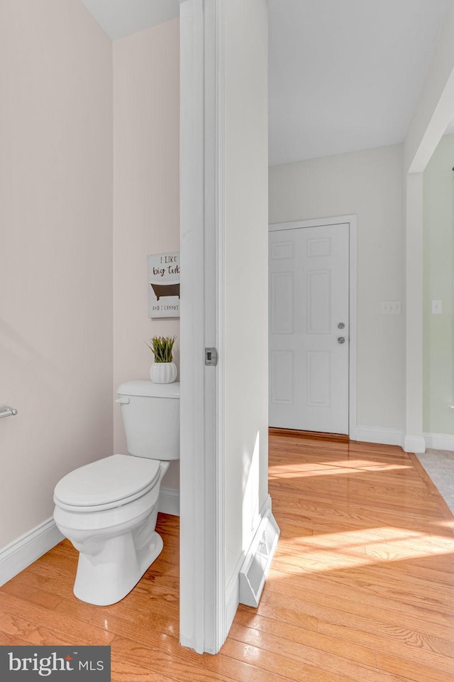bathroom with toilet, baseboards, visible vents, and hardwood / wood-style floors