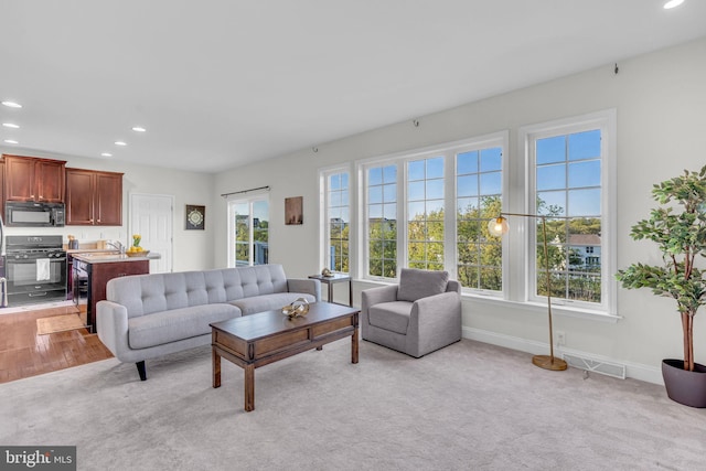 living room featuring recessed lighting, baseboards, visible vents, and light carpet