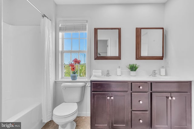 bathroom featuring plenty of natural light, a sink, double vanity, and toilet