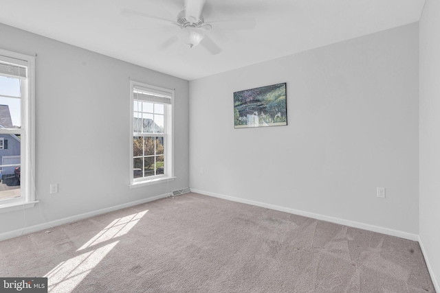 empty room featuring baseboards, carpet flooring, and visible vents