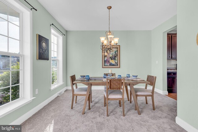 dining area featuring baseboards, visible vents, and an inviting chandelier