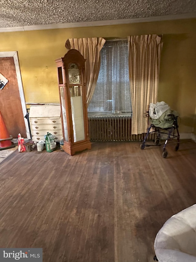 unfurnished living room with radiator heating unit and hardwood / wood-style flooring