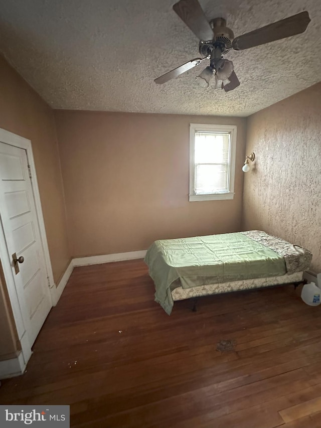 bedroom featuring a textured ceiling, wood finished floors, and a ceiling fan