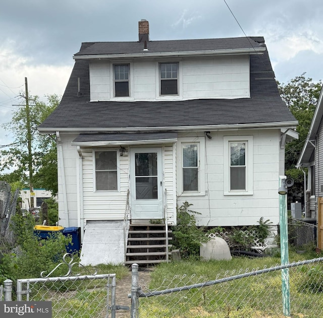view of front facade featuring a chimney, fence private yard, and entry steps