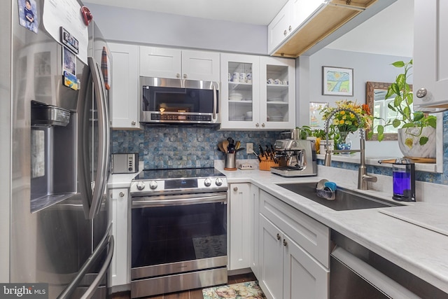 10230 Faire Commons Ct, Burke, VA 22015 - kitchen featuring appliances with stainless steel finishes, a sink, light countertops, glass insert cabinets, and white cabinetry