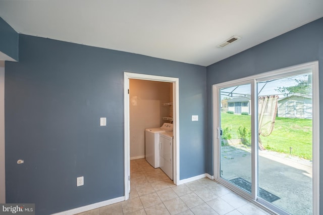 interior space featuring light tile patterned floors, visible vents, washing machine and clothes dryer, and baseboards