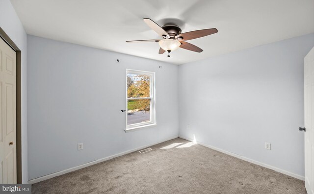 unfurnished bedroom with a closet, carpet, ceiling fan, baseboards, and visible vents