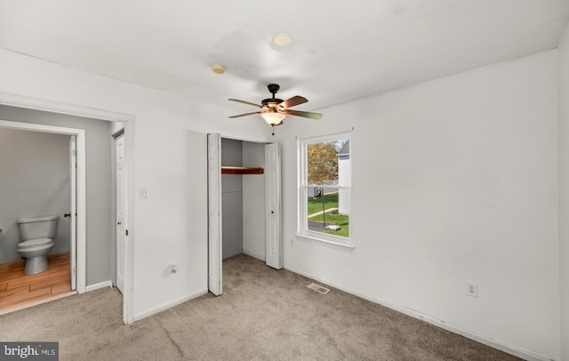 unfurnished bedroom with baseboards, visible vents, a closet, and light colored carpet