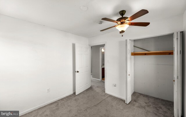 unfurnished bedroom with a closet, carpet flooring, ceiling fan, and baseboards