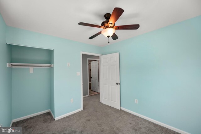 unfurnished bedroom featuring carpet, ceiling fan, a closet, and baseboards