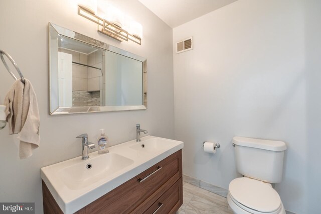 full bathroom featuring a sink, toilet, marble finish floor, double vanity, and visible vents