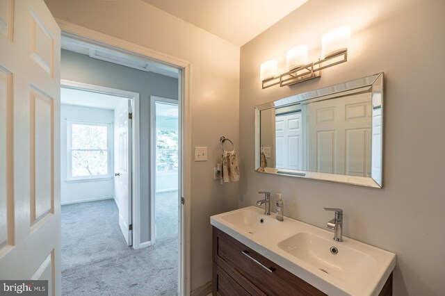 bathroom with double vanity, baseboards, and a sink