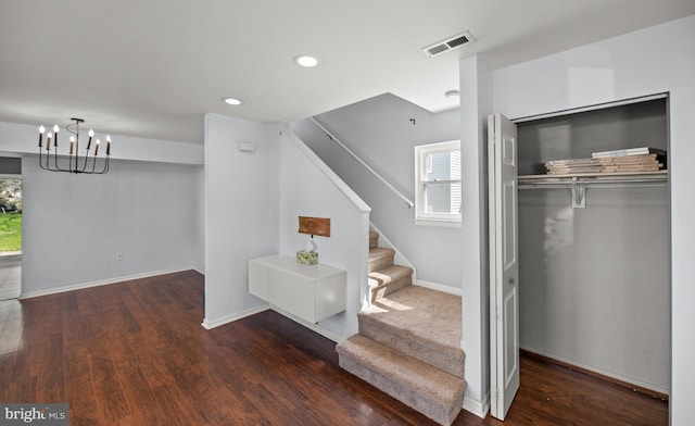 staircase featuring recessed lighting, a notable chandelier, visible vents, baseboards, and wood finished floors