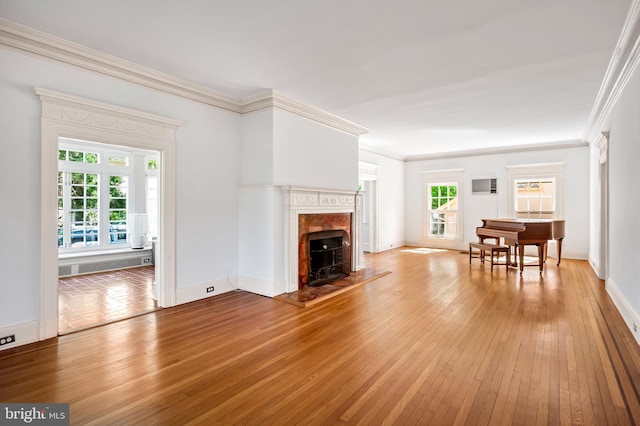 living room with baseboards, ornamental molding, light wood finished floors, and a premium fireplace