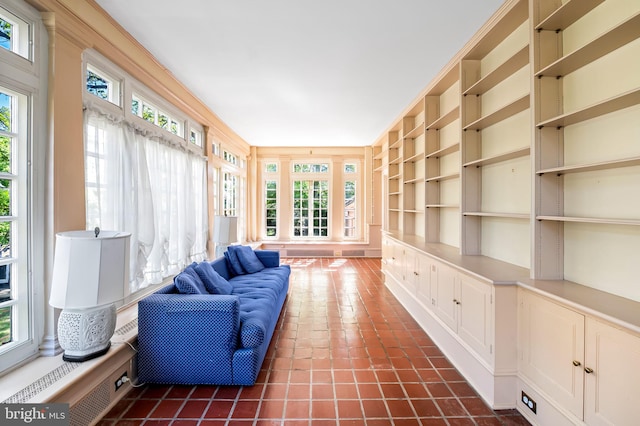 living area featuring a healthy amount of sunlight, built in features, and dark tile patterned flooring