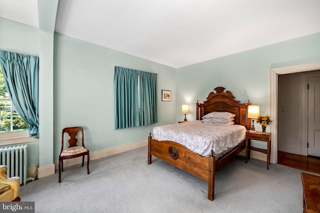carpeted bedroom featuring baseboards and radiator