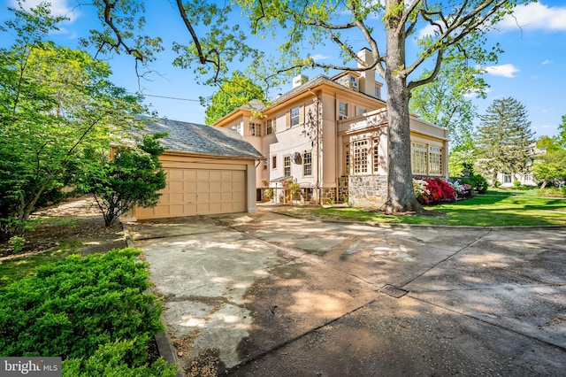 view of front of property featuring a garage, stucco siding, a front lawn, and stone siding