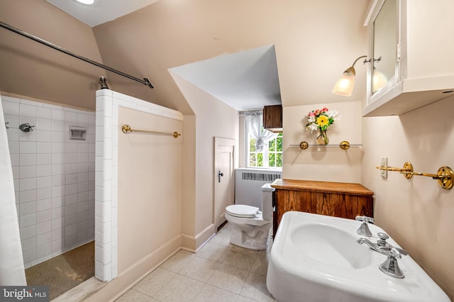 full bathroom featuring tile patterned flooring, toilet, radiator heating unit, tiled shower, and a sink