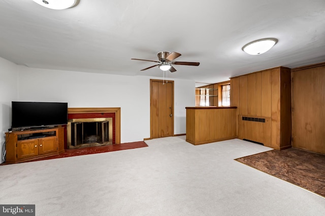unfurnished living room featuring carpet floors, ceiling fan, and a brick fireplace