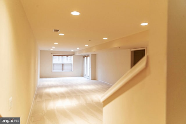 hall featuring recessed lighting, visible vents, light colored carpet, and baseboards