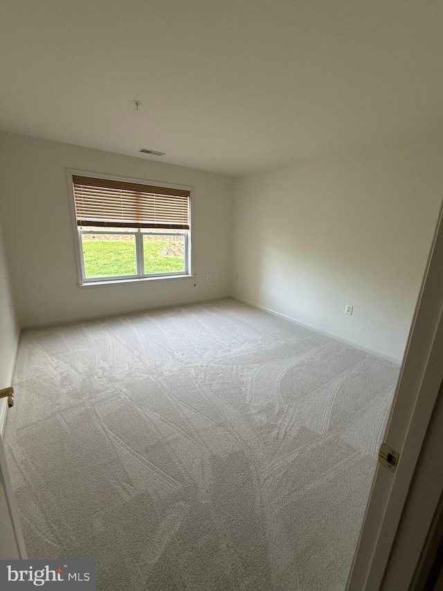 unfurnished room featuring carpet and baseboards